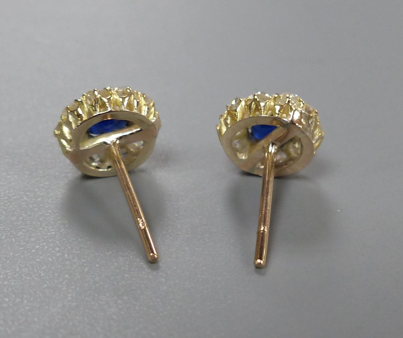 A pair yellow metal, sapphire and diamond circular cluster earstuds (no butterflies), diameter 8mm, gross 1.6 grams.